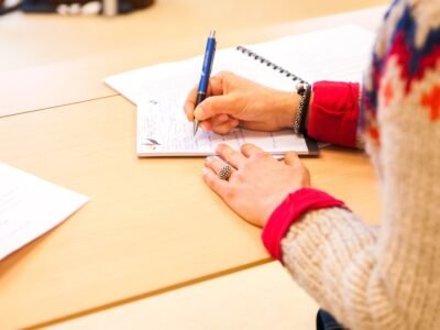 Persona tomando notas en una libreta durante una formación