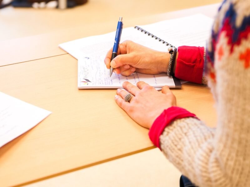 Persona tomando notas en una libreta durante una formación