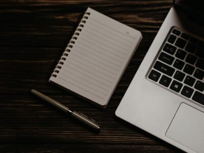 Escritorio minimalista con portátil y libreta para implantar Holded