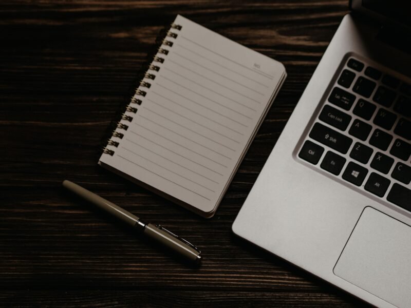 Escritorio minimalista con portátil y libreta para implantar Holded