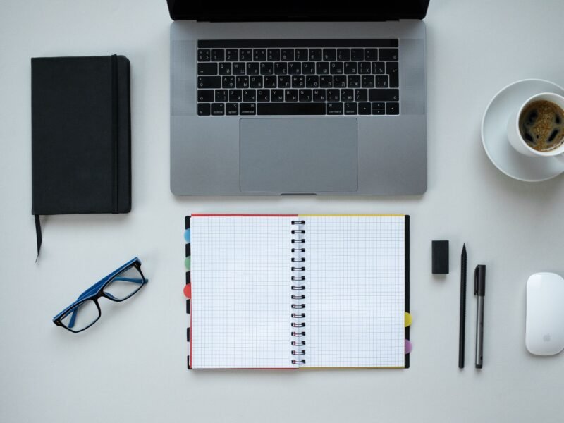 Escritorio con portátil, libreta y taza de café, plano cenital, para elegir un experto en Holded